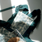 Deep teal lace baking cotton cross-back apron laid flat