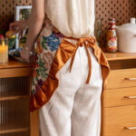 Vintage floral kitchen apron orange print, styled in warm kitchen decor