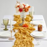 mustard yellow boho polyester table runner on a dining table with orange decor