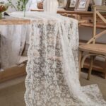 white lace embroidered tablecloth draped over table to show length and texture