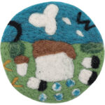 close-up of handmade wool felt coaster spring prairie design with sheep and flowers