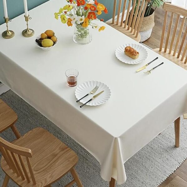 stain resistant tablecloths Waterproof, solid off white cotton linen waterproof tablecloth laid on indoor rectangular dining table, farmhouse home decor