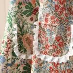 Close-up of Mia Floral and Peony Garden aprons, lace ruffle trim and floral print details on polyester fabric
