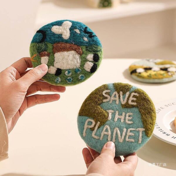 handmade wool felt coaster save the earth and spring prairie designs held in hands