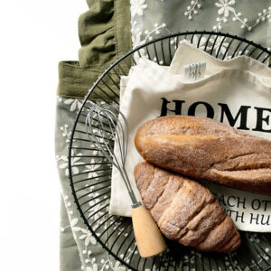Forest green lace baking cotton half apron styled with bread and wire basket