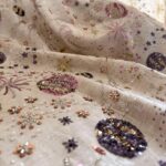 fabric texture close up of vintage floral curtain panel, soft beige botanical print drapery with natural folds and wrinkles