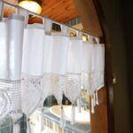 single‑piece white tie top window valance with crochet heart tassels hung on kitchen arch doorway