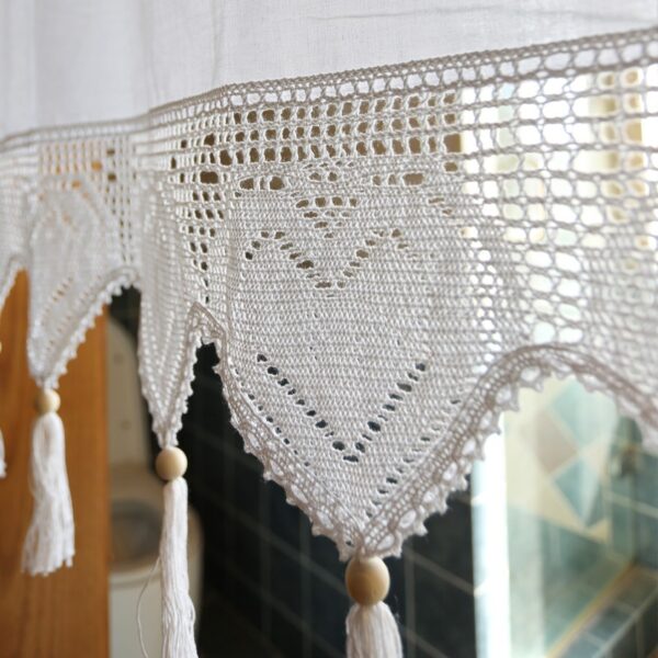 close‑up of crochet heart lace hem with hanging tassels on white tie‑top window valance