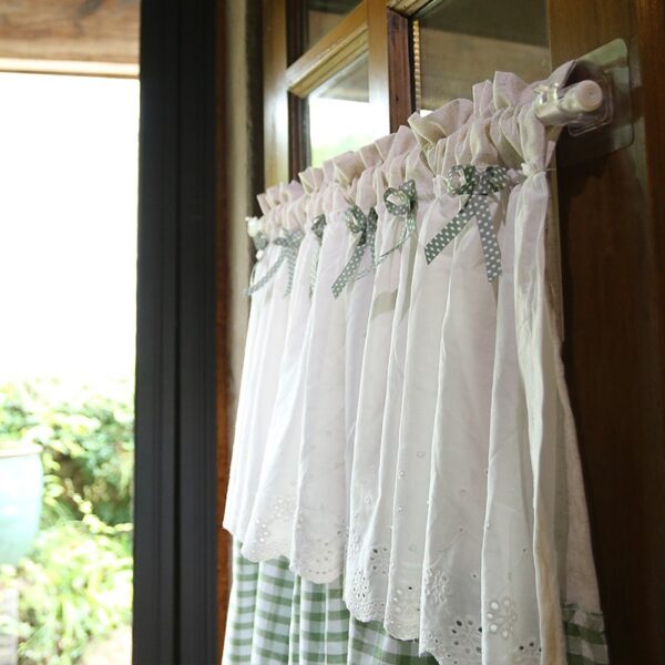 Farmhouse‑style short lace window curtain hanging on kitchen window