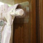 Self‑adhesive no‑drill curtain rod hook holding short kitchen cafe curtain