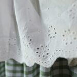 Hollow‑out embroidered lace trim detail on white kitchen tier curtain