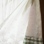 Light‑filtering sheer white lace curtain fabric transmitting sunlight