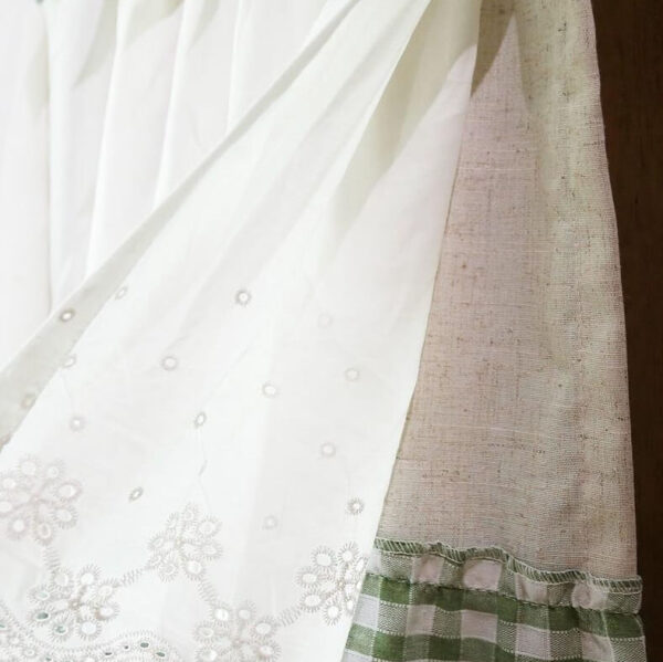 Light‑filtering sheer white lace curtain fabric transmitting sunlight