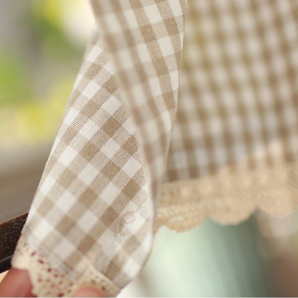 Beige brown gingham cafe curtain fabric close-up, linen texture with scalloped lace hem, farmhouse short window curtain material detail