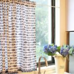 Farmhouse blue fish cafe curtain hanging beside kitchen window, rustic home decor
