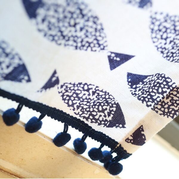 Close‑up of pom‑pom fringe trim on farmhouse blue fish cotton kitchen curtain