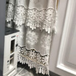 White lace‑trim short curtain hung on home kitchen indoor window
