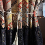 Bohemian print curtain tied back with rope tie, decorative boho fabric curtain detail