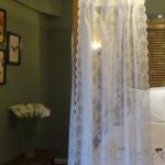 Long romantic sheer doorway curtain hanging in bedroom doorway