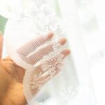 Romantic sheer white lace doorway curtain fabric close‑up