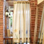 Cottage‑core floral short curtain hung above kitchen sink window, home‑style display