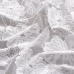 Close-up of 3D jacquard camellia lace texture on white rectangular tablecloth