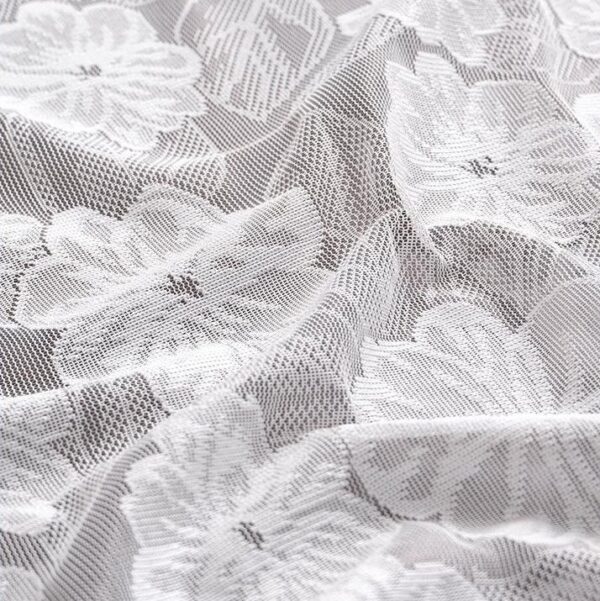 Close-up of 3D jacquard camellia lace texture on white rectangular tablecloth
