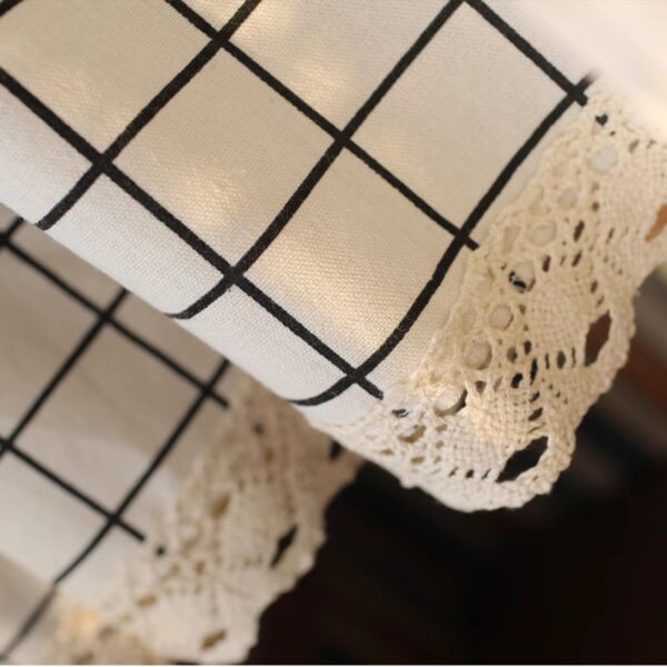 Close‑up of linen‑texture black grid curtain fabric, crochet lace trim detail