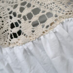 Macro shot of hollow‑out crochet lace embroidery on boho kitchen curtain header