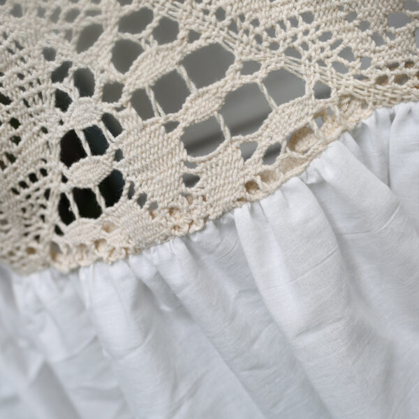 Macro shot of hollow‑out crochet lace embroidery on boho kitchen curtain header