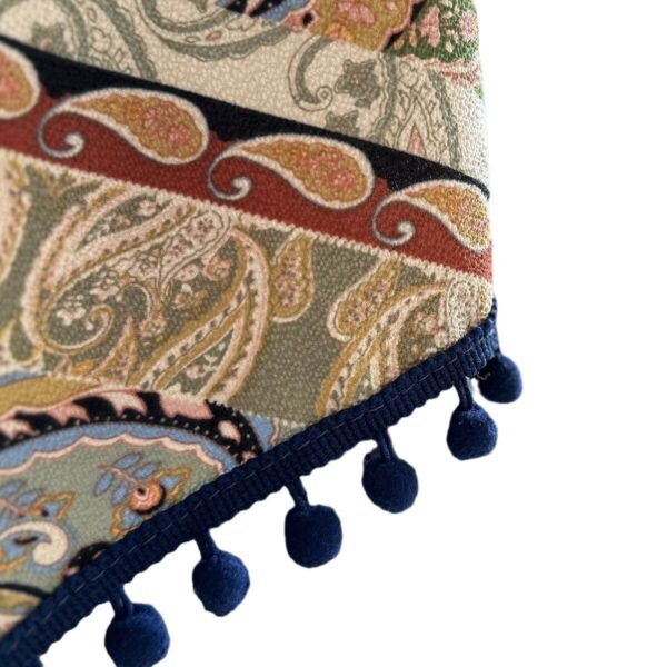 Close‑up of navy blue pom‑pom tassel fringe on vintage boho piano cover