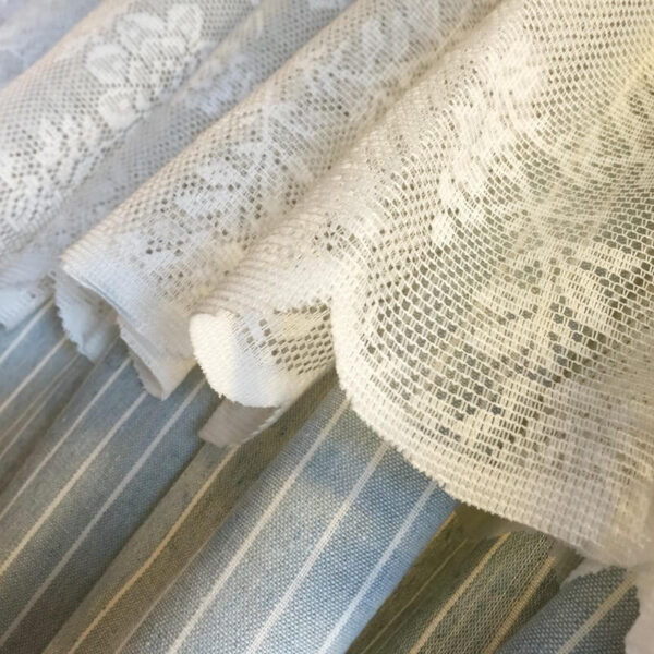 Close‑up of lace top and striped fabric on blue striped doorway curtain