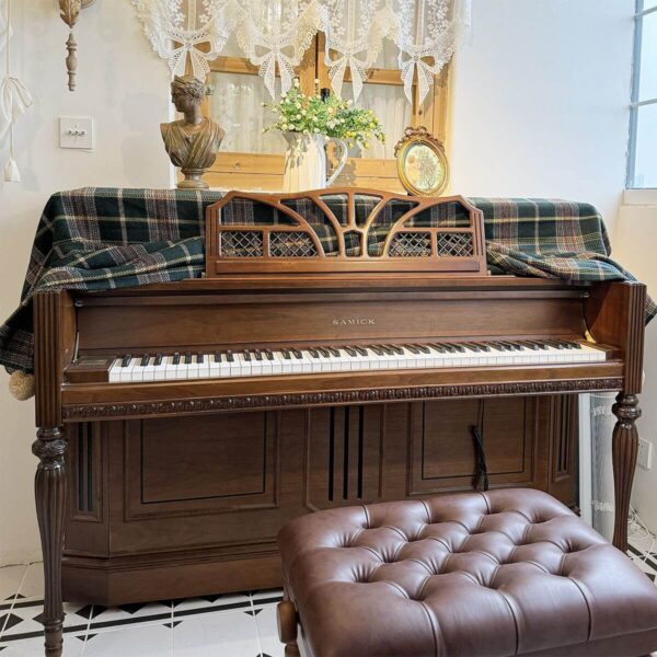 British vintage plaid piano dust cover laid over wooden upright piano in music room