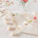 Back detail shot of tropical floral table cloth with tassel trim