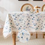Tropical floral table cloth with blue flowers and tassels on dining table