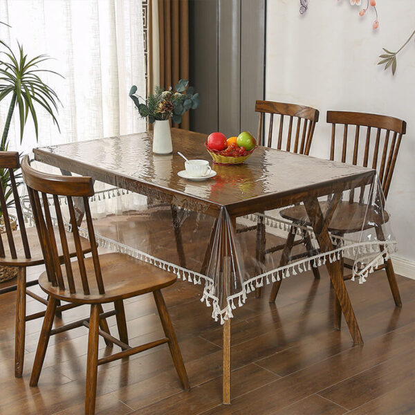 Clear lace‑trimmed vinyl table protector on farmhouse wooden dining table