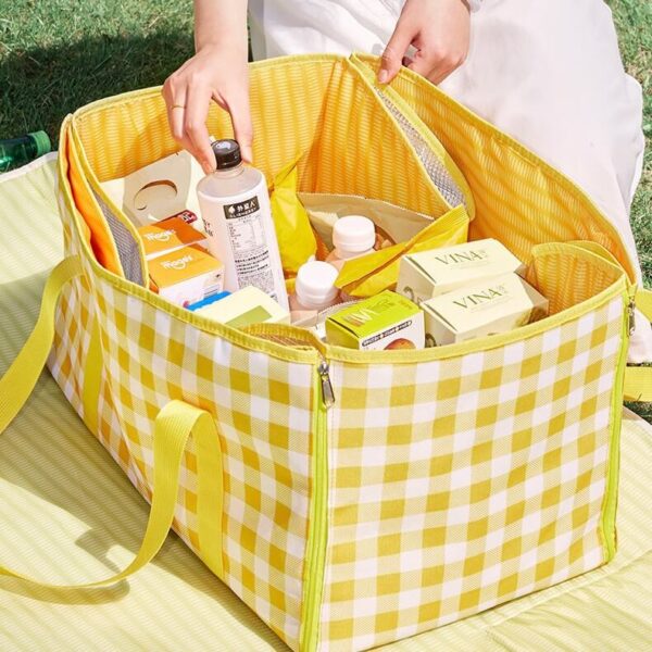 Yellow‑white check picnic tote blanket packed with outdoor food supplies