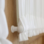 close‑up detail of white dual rod pocket curtain corner and fabric texture