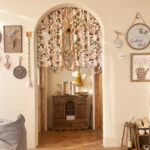 Warm vintage cream rose french curtain hanging on arch window, cottage cafe interior decor