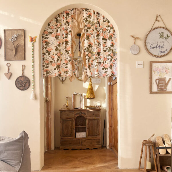 Warm vintage cream rose french curtain hanging on arch window, cottage cafe interior decor