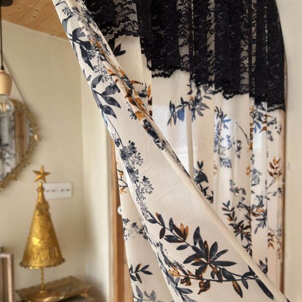 Close‑up floral fabric detail on timeless Parisian short curtain, black‑blue flower print with black lace header