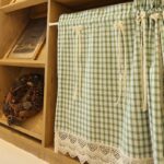 Full view plaid farmhouse cafe curtain with rod pocket hanging on curtain rod, lace hem