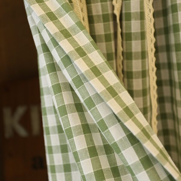 Green white plaid farmhouse cafe curtain fabric close-up with lace trim, 60 polyester 40 cotton texture