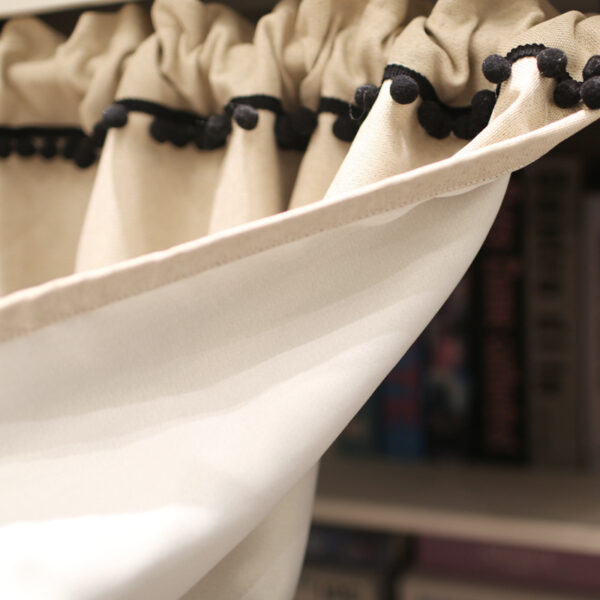 Close‑up of black pom‑pom hem on modern semi‑blackout short curtain single panel