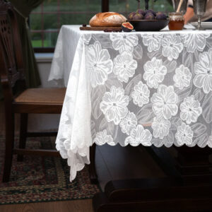 Decorative white camellia lace tablecloth with scalloped border on rectangular table