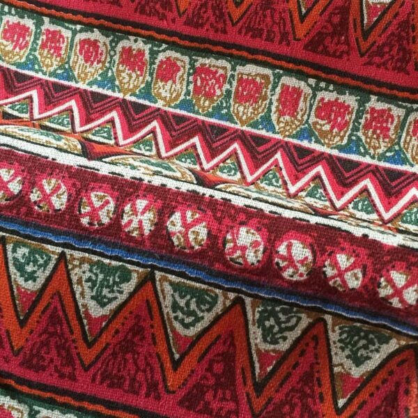 Close‑up view of bohemian geometric tier curtain, red vintage ethnic pattern fabric texture
