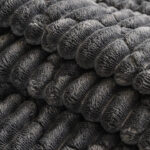 Close‑up view of thick plush textured fabric of sofa throw cover, cozy quilted surface