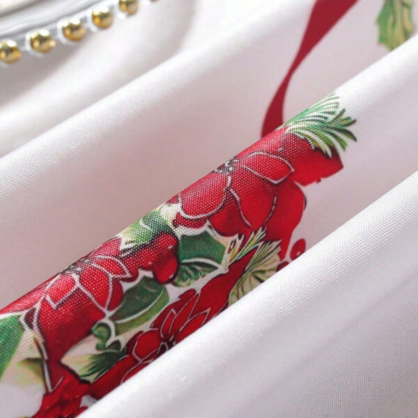 Rolled christmas tablecloth showing poinsettia and holly fabric texture