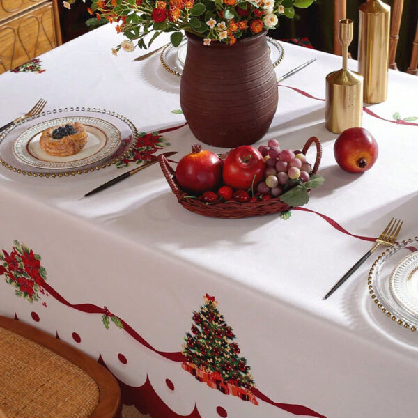 Festive christmas table setting with printed holly tablecloth for holiday dinner