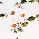 Close‑up view of holly berry print on white christmas tablecloth